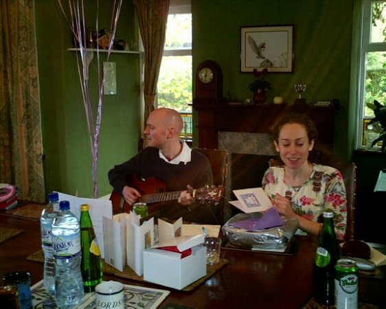 James plays while Joy opens Wedding Presents